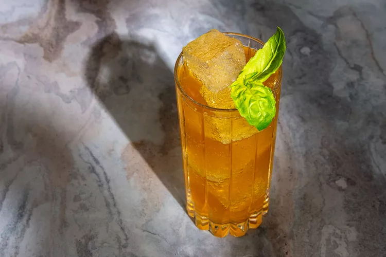 Irish Buck Cocktail in a glass with an orange coloring and 2 ice rocks