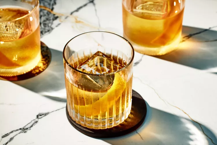 Old Fashioned cocktail in a glass with an orange twist and a cherry